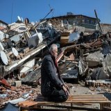 A man prays atop destroyed home in Hatay, Turkiye  - the site of a second 6.4M earthquake yesterday