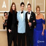 第95回米アカデミー賞授賞式で、ブレンダン・フレイザー（主演男優賞）が息子、パートナーと写真を撮影する中、後ろから姿を見せるキー・ホイ・クァン（助演男優賞）。ハリウッドで12日撮影。REUTERS/Mike Blake