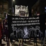 A black sign depicts the separation barrier, guard towers and barbed wire that contain the West Bank; in the middle, a dove bearing an olive branch. &ldquo;A nation that occupies another nation will never be free,&rdquo; says the sign in Arabic, Hebr