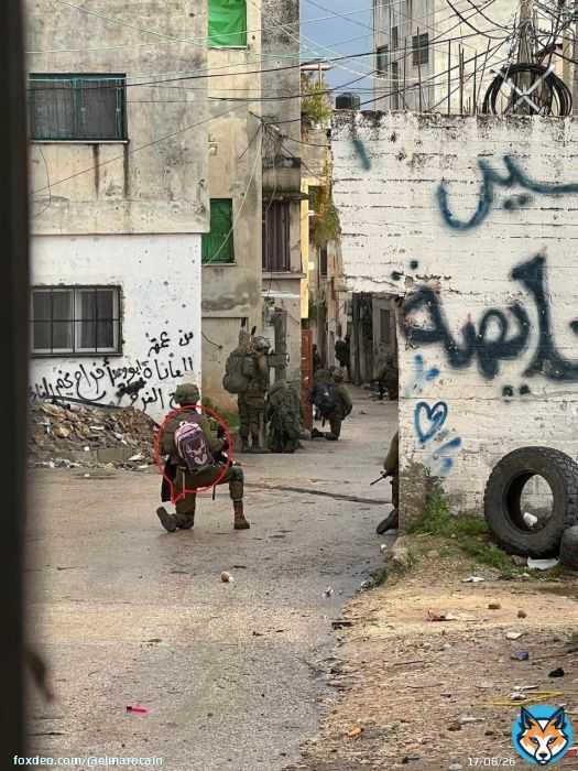 A Zionist terrorist soldier steals a school bag belonging to a Palestinian child on her way home.