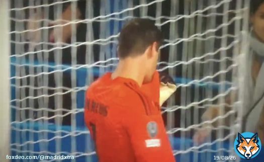 Courtois kissing the Real Madrid badge in front of Chelsea supporters.