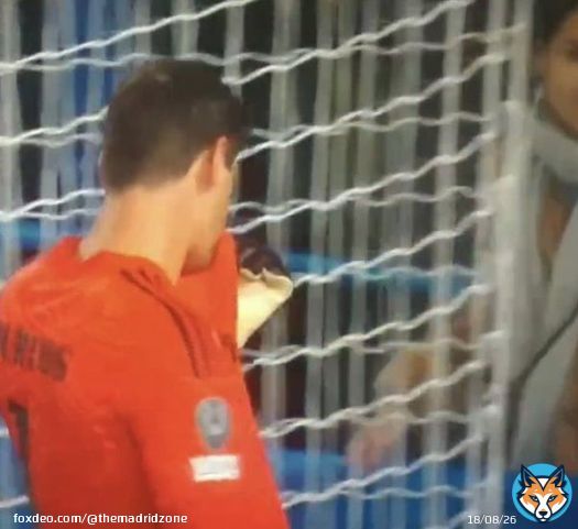 Thibaut Courtois kisses the Real Madrid badge in front of the Chelsea fans.