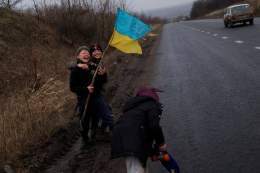 Дитинство живе всюди.   Бахмут. Діти тримають український прапор і щиро сміються. Саме ці посмішки надихають наших військових і допомагають в тяжких боях.   Фото &mdash; Reuters.
