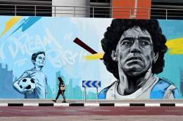#RoadtoQatar   A woman walks past a mural painting depicting Argentinian football legend Diego #Maradona near the Khalifa International Stadium in Doha .. ahead of the #Qatar2022  World Cup football tournament   #المونديال_مع_الجزار #Argentina